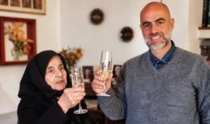 Pietro Mereu con una donna anziana durante un brindisi