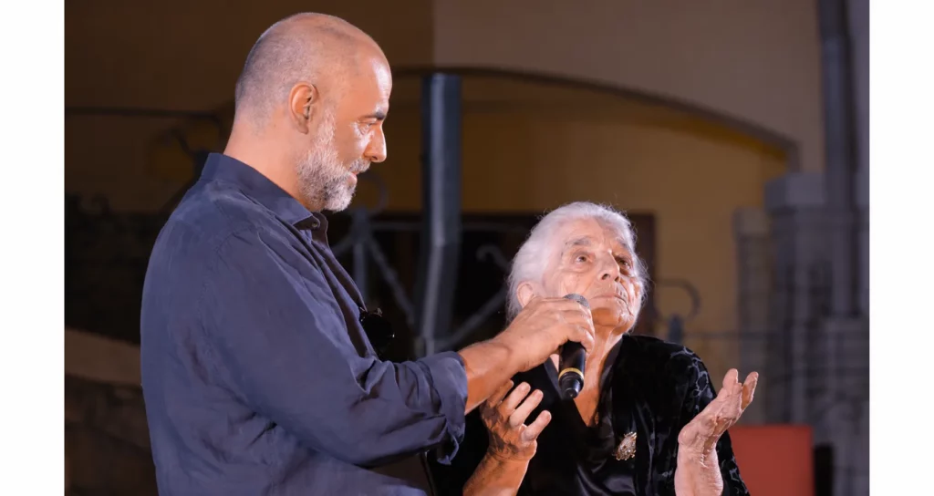 Pietro Mereu con un uomo anziano durante un incontro pubblico